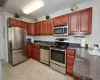 Kitchen with dark countertops, visible vents, appliances with stainless steel finishes, a sink, and a peninsula