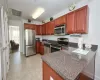 Kitchen with stainless steel appliances, dark countertops, backsplash, and visible vents