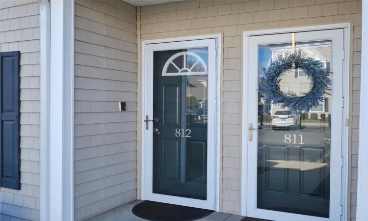 Townhome / multi-family property with a porch and roof with shingles