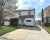 View of front of house with concrete driveway, a front lawn, fence, and a gate