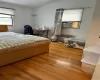 Bedroom featuring cooling unit, lofted ceiling, radiator heating unit, and wood finished floors