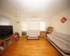 Living room with ornamental molding, light wood finished floors, a wall unit AC, and a wall mounted air conditioner