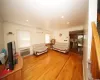 Living area with a wall unit AC, crown molding, and light wood-style flooring