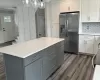 Kitchen with stainless steel fridge, tasteful backsplash, crown molding, and gray cabinetry