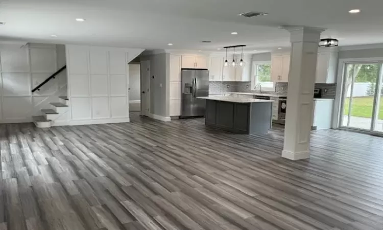 Kitchen with a healthy amount of sunlight, stainless steel refrigerator with ice dispenser, a sink, and open floor plan