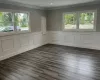 Empty room with dark wood-style floors, ornamental molding, a wainscoted wall, and recessed lighting