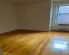 Unfurnished room featuring baseboards, light wood-style flooring, and radiator