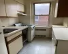 Kitchen with black dishwasher, radiator, light countertops, under cabinet range hood, and a sink