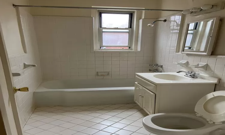 Full bathroom with  shower combination, tile walls, vanity, and tile patterned floors