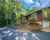 View of front of house featuring stairs, decorative driveway, a chimney, and a garage