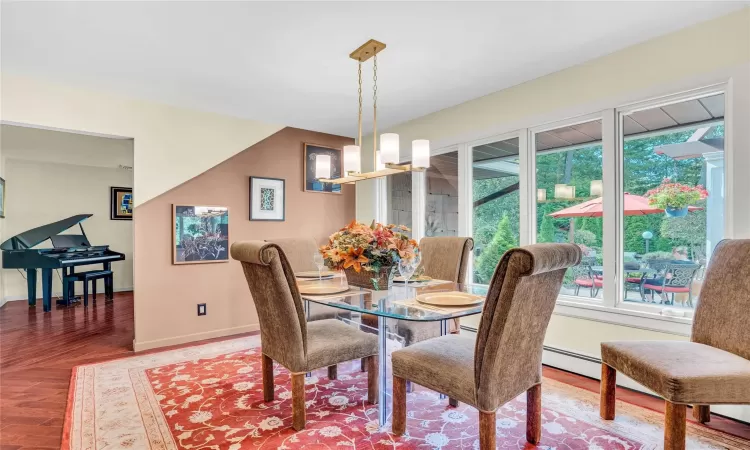 Dining room featuring wood finished floors, baseboards, and an inviting chandelier