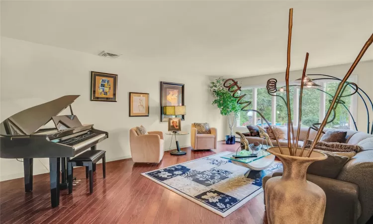 Living area with visible vents, baseboards, and wood finished floors