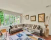 Living room with a baseboard radiator, visible vents, and wood finished floors