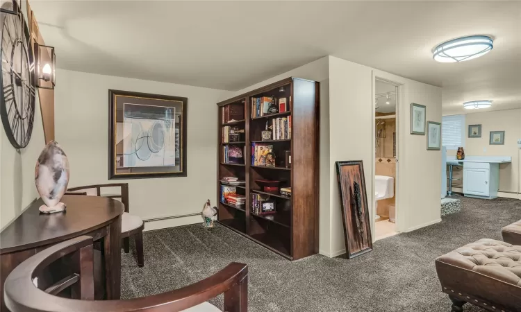 Sitting room in basement with carpet and full bath.