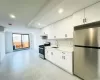 Kitchen with tasteful backsplash, white cabinets, appliances with stainless steel finishes, under cabinet range hood, and a sink