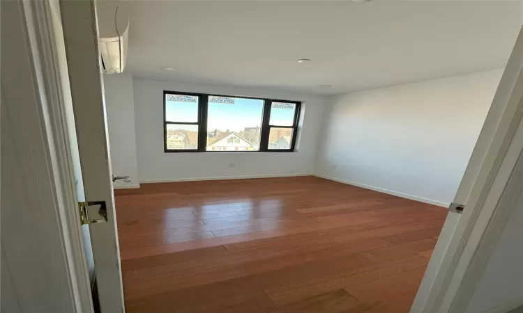 Empty room with baseboards and wood-type flooring