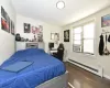 Bedroom featuring cooling unit, dark wood finished floors, and baseboard heating