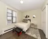 Bedroom with baseboards, radiator heating unit, dark wood-type flooring, cooling unit, and a closet