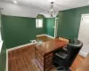 Bedroom used as an office with baseboards, visible vents, wood finished floors, vaulted ceiling, and a chandelier