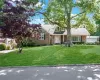 View of front of home featuring brick siding, a shingled roof, and a front yard