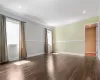 Empty room with ornamental molding, recessed lighting, dark wood finished floors, and baseboards