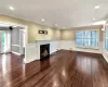 Unfurnished living room with visible vents, a fireplace with flush hearth, ornamental molding, dark wood-style flooring, and recessed lighting