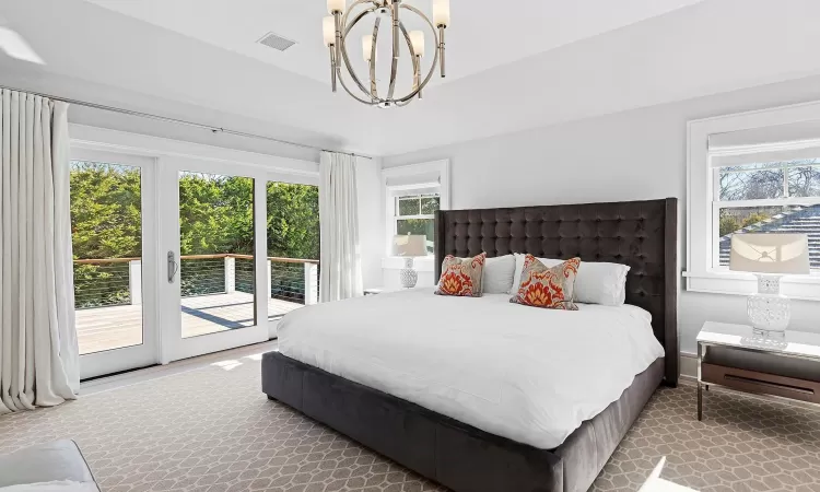 Bedroom with a chandelier, access to outside, and visible vents