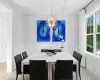 Dining space with a wainscoted wall, coffered ceiling, a wealth of natural light, and a notable chandelier