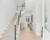 Foyer with light wood-style flooring, recessed lighting, a decorative wall, stairs, and crown molding