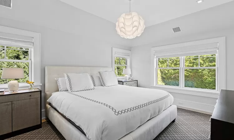 Bedroom featuring baseboards, visible vents, and a chandelier