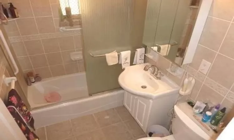 Bathroom with vanity, shower / washtub combination, tile patterned flooring, and toilet