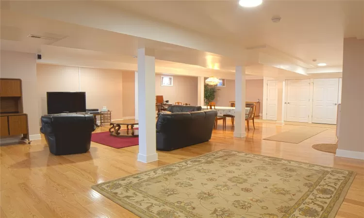 Living room featuring recessed lighting, light wood-type flooring, visible vents, and baseboards