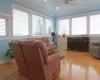 Living room featuring baseboards, ceiling fan, crown molding, light wood-style floors, and a fireplace