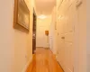 Corridor featuring light wood-style flooring and baseboards