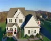 View of front of home with covered porch and roof with shingles