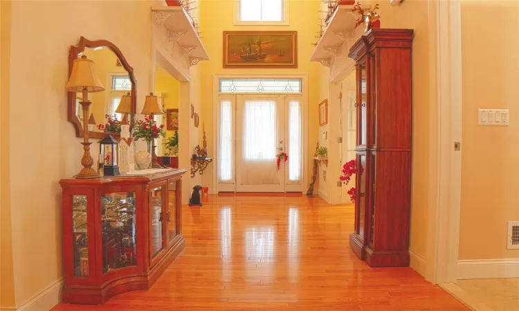 Foyer featuring baseboards, visible vents, and light wood finished floors