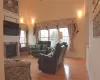 Living room featuring a towering ceiling, light wood finished floors, a fireplace, and a healthy amount of sunlight