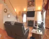 Living room with a fireplace, light wood finished floors, stairway, a high ceiling, and baseboards