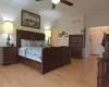 Bedroom featuring ceiling fan, light wood finished floors, visible vents, and crown molding