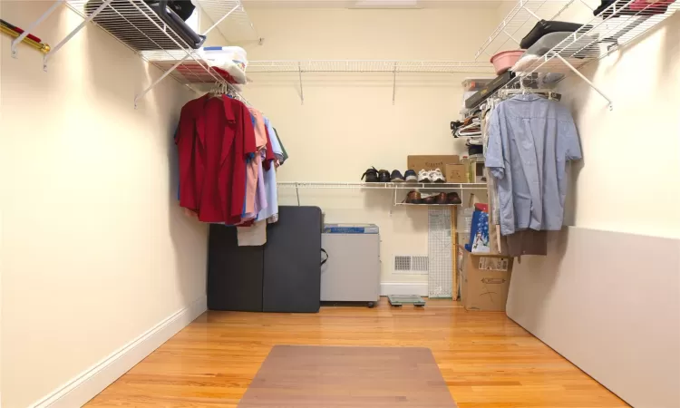 Walk in closet featuring visible vents and wood finished floors