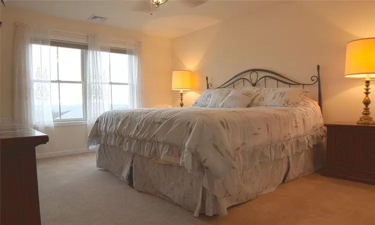 Bedroom featuring baseboards, visible vents, and light colored carpet