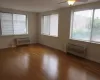 Empty room featuring a wall unit AC, baseboards, and wood finished floors