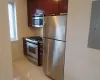 Kitchen featuring appliances with stainless steel finishes, electric panel, baseboards, and light tile patterned floors