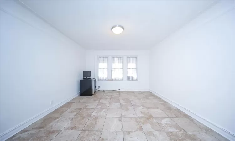 Empty room with light tile patterned flooring and baseboards