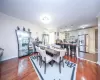 Dining area with a wall mounted AC, hardwood / wood-style flooring, and crown molding