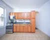 Kitchen featuring arched walkways, stainless steel appliances, a sink, tasteful backsplash, and dark countertops