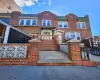 View of front of house featuring a tile roof, brick siding, concrete driveway, fence, and a garage