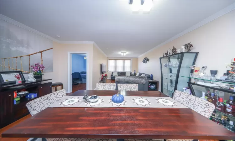 Dining area featuring wood finished floors and crown molding