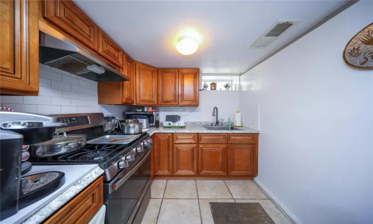 Unfurnished room featuring arched walkways, light tile patterned flooring, and baseboards