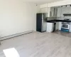 Kitchen with under cabinet range hood, a sink, appliances with stainless steel finishes, decorative backsplash, and dark countertops